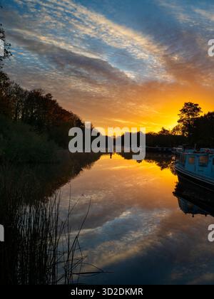 Blick vom Fußweg über das Abingdon Weir an der Themse, spektakulärer Wintersonnenaufgang Abingdon-on-Thames behauptet, die älteste Stadt Englands zu sein. Und die Themse fließt durch ihr Herz. In dieser idyllischen Szene sehen wir von den Abingdon Locks aus einen recht schönen Blick auf den Fluss, gerade während die Sonne an einem schönen Wintermorgen aufgeht. So ruhig... Stockfoto