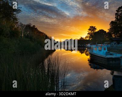 Blick vom Fußweg über das Abingdon Weir an der Themse, spektakulärer Wintersonnenaufgang Abingdon-on-Thames behauptet, die älteste Stadt Englands zu sein. Und die Themse fließt durch ihr Herz. In dieser idyllischen Szene sehen wir von den Abingdon Locks aus einen recht schönen Blick auf den Fluss, gerade während die Sonne an einem schönen Wintermorgen aufgeht. So ruhig... Stockfoto