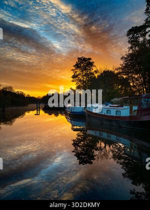 Blick vom Fußweg über das Abingdon Weir an der Themse, spektakulärer Wintersonnenaufgang Abingdon-on-Thames behauptet, die älteste Stadt Englands zu sein. Und die Themse fließt durch ihr Herz. In dieser idyllischen Szene sehen wir von den Abingdon Locks aus einen recht schönen Blick auf den Fluss, gerade während die Sonne an einem schönen Wintermorgen aufgeht. So ruhig... Stockfoto