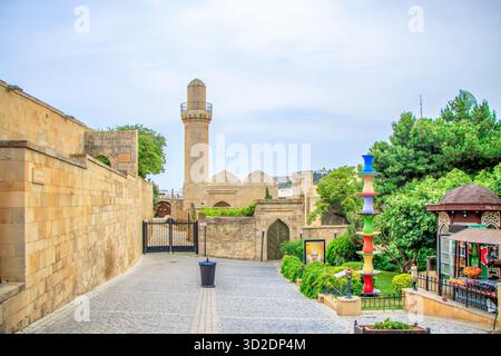 Baku, Aserbaidschan. Der Sonnenuntergang des Minaretts der Shah-Moschee erhebt sich über den umliegenden Gebäuden. Stockfoto