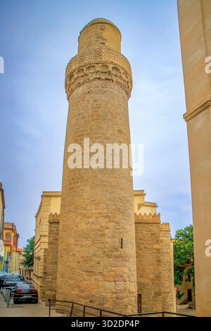 Baku, Aserbaidschan. Der Sonnenuntergang des Minaretts der Shah-Moschee erhebt sich über den umliegenden Gebäuden. Stockfoto