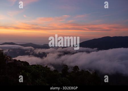 Die Landschaft steht kurz vor Sonnenaufgang. Die Skyline ist orange mit Nebel über den Bergen. Die Luft ist hell. Die Schönheit von oben am Morgen ist erstaunlich Stockfoto
