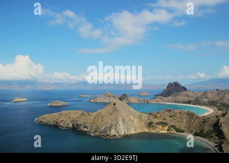 Atemberaubender Blick auf die zerklüfteten Hügel und türkisfarbenen Buchten von Padar Island unter klarem blauen Himmel im Komodo-Nationalpark, Indonesien Stockfoto