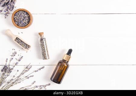 Kosmetische Bio-Lavendelprodukte für die Körperhautpflege in Glasflaschen. Draufsicht. Flaches Layout. Eine Kopie des Bereichs. Weißer Holzhintergrund Stockfoto