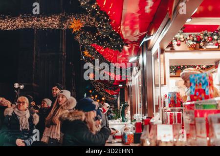 Köln, Deutschland, 10. Dezember 2022 - Besucher genießen den Weihnachtsmarkt im Freien, Stände mit Weihnachtsbeleuchtung, Abend Stockfoto
