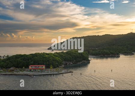 Wenn das erste Licht der Dämmerung über Haiti bricht, entfaltet sich eine atemberaubende Landschaft des Sonnenaufgangs: goldene Strahlen durchdringen den Horizont und strahlen ein warmes Licht über den Stockfoto