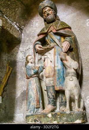 Stiftskirche Saint-Léonard, Saint-Léonard de Noblat, Haute-Vienne, Nouvelle-Aquitaine. Statue des Heiligen roch in einer Nische. Polychromer Stein, 16 Stockfoto
