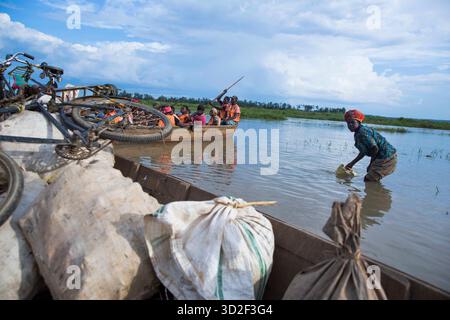Bugesera, Ruanda. Die Bewohner von Sharita Island waten durch den überfluteten Nyagisenyi River in Bugesera und zeigen die Auswirkungen der saisonalen Überschwemmungen. Stockfoto