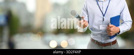 Journalist mit Mikrofon und Notebook im Freien, Nahaufnahme. Bannerdesign Stockfoto