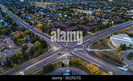Drohnenblick auf eine große Autobahnkreuzung mit Verkehr umgeben von Herbstlaub in Edmonton, Kanada Stockfoto