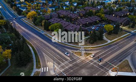 Luftdrohnenfoto von Stadtstraßen und Wohngebieten umgeben von Herbstbäumen. Edmonton, Kanada Stockfoto