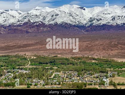 Luftaufnahme der Stadt Uspallata mit den Anden im Hintergrund, vollständig mit Schnee bedeckt, Mendoza Stockfoto