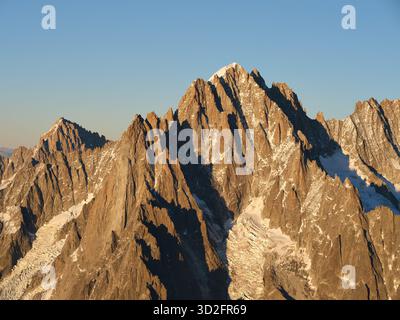 LUFTAUFNAHME. Aiguille Verte (4122 m) und les Drus (3754 m) mit Blick auf den Glacier de la Charpoua im warmen Licht des späten Nachmittags. Chamonix, Frankreich. Stockfoto