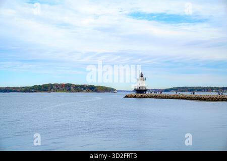 Ein ruhiger Blick auf die Küste mit dem Spring Point Ledge Lighthouse in Portland, Maine, der am Ende einer felsigen Wellenbrecher unter weichen Wolken steht Stockfoto