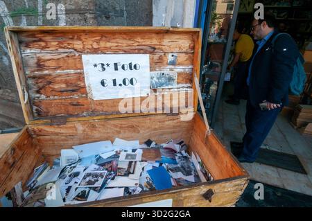 Eine Holzkiste mit Vintage-Fotos zum Verkauf vor einem Geschäft auf der Piazza Dante, Neapel. Stockfoto