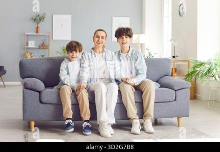 Mom und ihre Kinder verbringen zu Hause Zeit zusammen, sitzen auf dem Sofa. Stockfoto