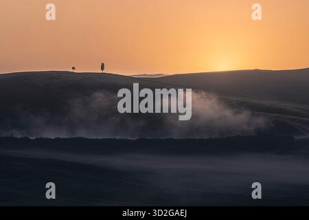 Nebliger Sonnenaufgang über toskanischen Hügeln Stockfoto