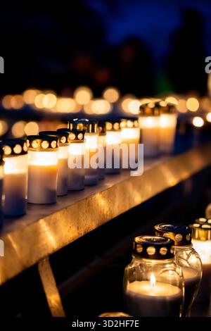 Reihen von Grabkerzen im Dunkeln am Allerheiligen in Skogskyrkogården mit Bokeh-Effekt Stockfoto