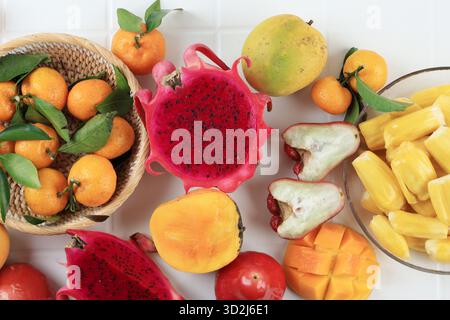 Top View Verschiedene Tropische Früchte, Drachenfrucht, Mango, Jackfrucht, Mandarine Orange, und Roter Rosenapfel auf weißem Holztisch Stockfoto