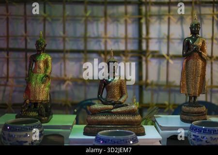 Drei friedliche Buddha-Statuen auf spirituellem Altar für Meditation und Religion. Ruhige Szene aus asiatischer Kultur, die Glauben, Glauben und Ruhe zeigt Stockfoto