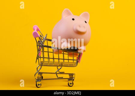 Einkaufswagen mit Schweinebank Nahaufnahme auf gelbem Hintergrund Stockfoto