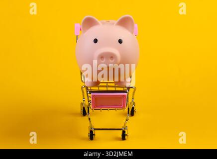 Einkaufswagen mit Schweinebank Nahaufnahme auf gelbem Hintergrund Stockfoto