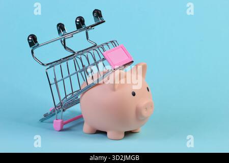 Einkaufswagen mit Schweinebank Nahaufnahme auf blauem Hintergrund Stockfoto