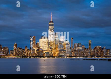 Blick in die Dämmerung auf die Skyline von Lower Manhattan mit Wolkenkratzern im World Trade Center. Malerische New York City Uferpromenade und Finanzviertel in der Abenddämmerung Stockfoto
