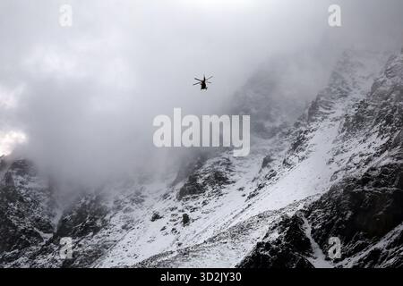 Bozen, Italien. November 2025. Ein Bergrettungshubschrauber fliegt vor dem verschneiten Ortlergebirge auf der Suche nach zwei vermissten Bergsteigern. Nach dem Tod von mindestens drei deutschen Bergsteigern bei einem Lawinenunfall in Südtirol wurde die Suche nach zwei Vermissten wieder aufgenommen. Quelle: Karl-Josef Hildenbrand/dpa/Alamy Live News Stockfoto