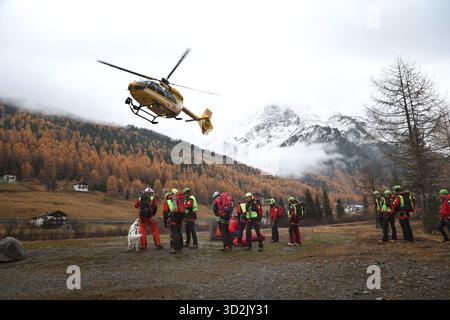 Bozen, Italien. November 2025. Ein Bergrettungshubschrauber landet vor Bergrettern. Nach dem Tod von mindestens drei deutschen Bergsteigern bei einem Lawinenunfall in Südtirol wurde die Suche nach zwei Vermissten wieder aufgenommen. Quelle: Karl-Josef Hildenbrand/dpa/Alamy Live News Stockfoto