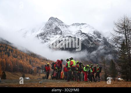 Bozen, Italien. November 2025. Mitglieder der Bergrettungstruppe warten auf den Rettungshubschrauber vor den verschneiten Ortlerbergen. Nach dem Tod von mindestens drei deutschen Bergsteigern bei einem Lawinenunfall in Südtirol wurde die Suche nach zwei Vermissten wieder aufgenommen. Quelle: Karl-Josef Hildenbrand/dpa/Alamy Live News Stockfoto