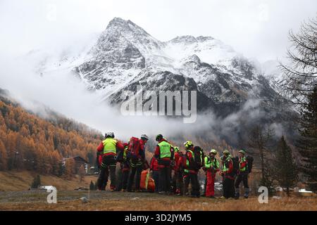Bozen, Italien. November 2025. Mitglieder der Bergrettungstruppe warten auf den Rettungshubschrauber vor den verschneiten Ortlerbergen. Nach dem Tod von mindestens drei deutschen Bergsteigern bei einem Lawinenunfall in Südtirol wurde die Suche nach zwei Vermissten wieder aufgenommen. Quelle: Karl-Josef Hildenbrand/dpa/Alamy Live News Stockfoto