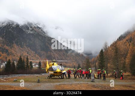 Bozen, Italien. November 2025. Mitglieder der Bergrettungstruppe treffen sich vor einem Rettungshubschrauber. Nach dem Lawinenunfall in Südtirol wurden auch die Leichen der beiden noch vermissten Deutschen gefunden. Es ist nun sicher, dass am Vortag insgesamt fünf Bergsteiger bei dem Unfall ums Leben kamen - alle aus Deutschland. Quelle: Karl-Josef Hildenbrand/dpa/Alamy Live News Stockfoto