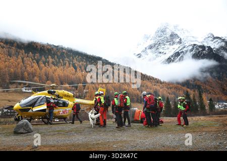 Bozen, Italien. November 2025. Mitglieder der Bergrettungstruppe treffen sich vor einem Rettungshubschrauber. Nach dem Lawinenunfall in Südtirol wurden auch die Leichen der beiden noch vermissten Deutschen gefunden. Das bedeutet, dass am Vortag insgesamt fünf Bergsteiger bei dem Unfall ums Leben kamen - alle aus Deutschland. Quelle: Karl-Josef Hildenbrand/dpa/Alamy Live News Stockfoto