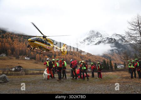 Bozen, Italien. November 2025. Ein Bergrettungshubschrauber landet vor Bergrettern. Nach dem Lawinenunfall in Südtirol wurden auch die Leichen der beiden noch vermissten Deutschen gefunden. Das bedeutet, dass am Vortag insgesamt fünf Bergsteiger bei dem Unfall ums Leben kamen - alle aus Deutschland. Quelle: Karl-Josef Hildenbrand/dpa/Alamy Live News Stockfoto