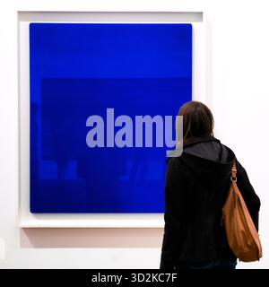 London, Vereinigtes Königreich - 12. Mai 2018 - Frau, die abstrakte blaue Kunstwerke im Tate Modern Museum in London, Vereinigtes Königreich betrachtet, Ausstellung minimalistischer Kunst Stockfoto