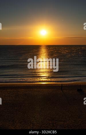 Wunderschöner Sonnenaufgang über dem Meer in Obzor, Bulgarien. Goldenes Sonnenlicht reflektiert auf ruhigen Wellen und leerem Sandstrand am ruhigen Sommermorgen. Stockfoto