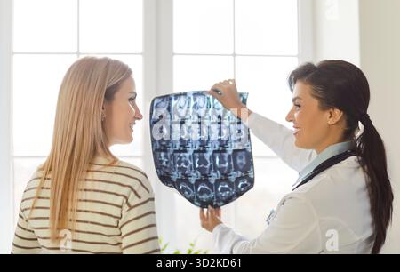 Die Ärztin zeigt dem Patienten ein Röntgenbild, erläutert das MRT-Bild und diskutiert den Behandlungsplan. Stockfoto