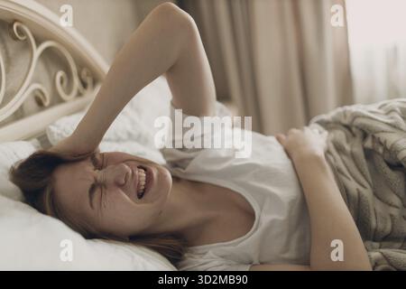 Junge Frau mit Kopfschmerz Grippe krank Krankheit kalt zu Hause im Haus liegen auf Bett Top View Stockfoto