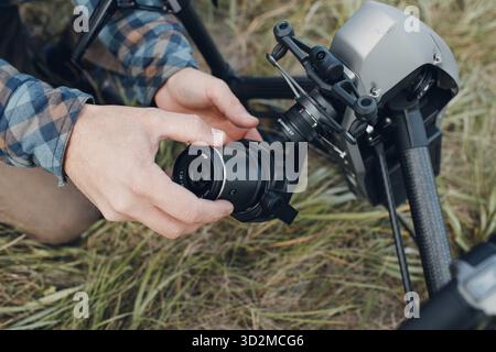 New York, USA - 18. SEPTEMBER 2021: Man Pilot überprüft die Quadcopter-Drohne DJI Inspire 2 und setzt vor dem Flug und den Dreharbeiten ein Kameraobjektiv an Stockfoto