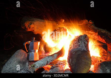 Kaffeekanne am offenen Feuer nachts. Brennendes Lagerfeuer. Nahaufnahme und isoliert. Stockholm, Schweden, Europa. Herbst 2022. Stockfoto