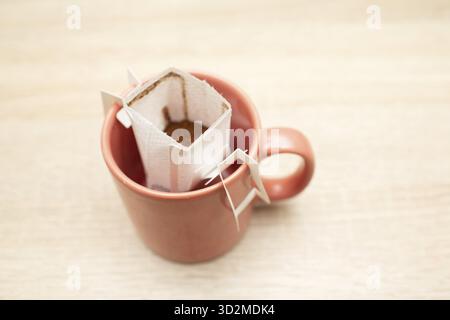 Kaffee tropft in der Tasse. Alternative Zubereitung von Spezialkaffee in Papierfilterbeuteln Stockfoto