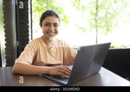 Indische Geschäftsfrau, die an ihrem Laptop-Café im Freien arbeitet Stockfoto