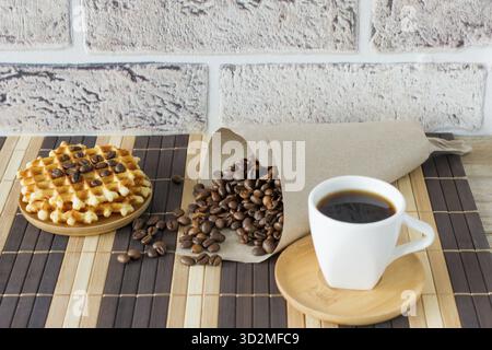 Zwei Tassen frisch gebrühter Espresso auf Holztisch. Kaffeebohnen auf hellem Holztisch, rustikaler Stil, hausgemacht Stockfoto