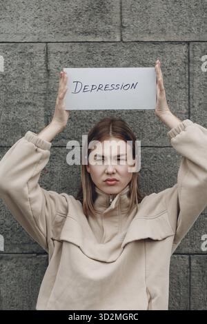 Frau hält weißes Blatt Papier beschriftet Wort Depression in der Hand Stockfoto