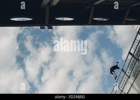 Junger sportlicher Kerl, der Parkour an der Stadtstraße macht Stockfoto