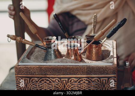 Die Türkischen arabischen Kaffee in den Sand in jezve Stockfoto