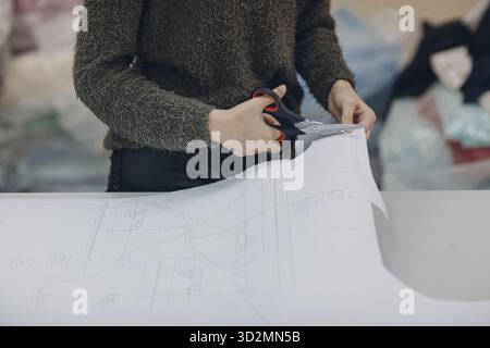 Junge schöne Schneiderin Schneiderin Kleidung Designer in einer Bekleidungsfabrik Stockfoto
