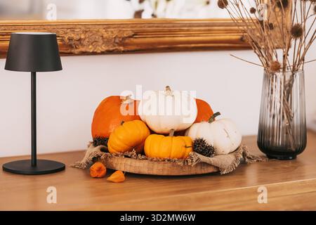 Herbstliche Dekoration mit verschiedenen Mini-Kürbissen auf einem hölzernen Sideboard Stockfoto