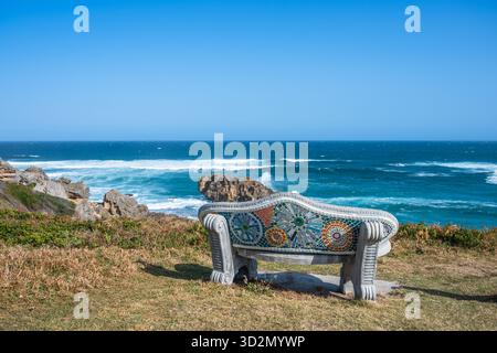 Leere Bank mit Meerblick - dekorierte Bank mit bunten Mosaikfliesen in Brenton on Sea, Südafrika, an einem sonnigen Nachmittag im Frühling. Kopierbereich Stockfoto